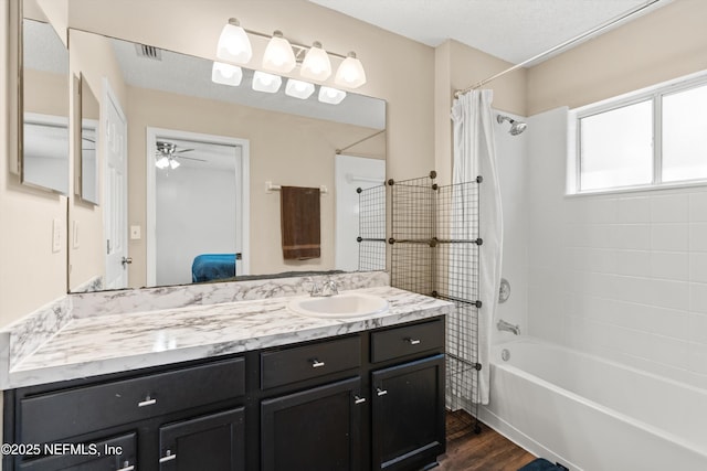 full bathroom featuring ensuite bathroom, wood finished floors, shower / bath combination with curtain, vanity, and a ceiling fan