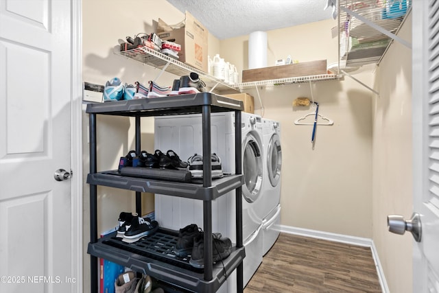 laundry room with baseboards, washer and clothes dryer, laundry area, wood finished floors, and a textured ceiling