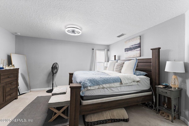 bedroom featuring baseboards, light colored carpet, visible vents, and a textured ceiling