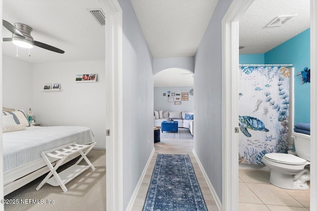 bedroom with visible vents, arched walkways, and a textured ceiling