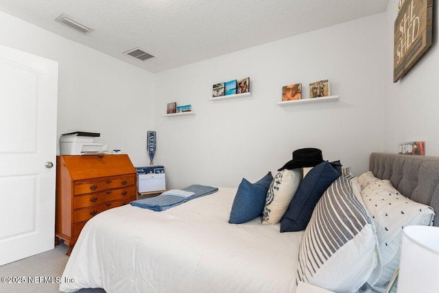 carpeted bedroom featuring visible vents and a textured ceiling