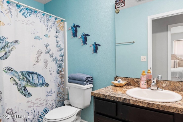 full bathroom with a shower with shower curtain, toilet, vanity, and a textured wall