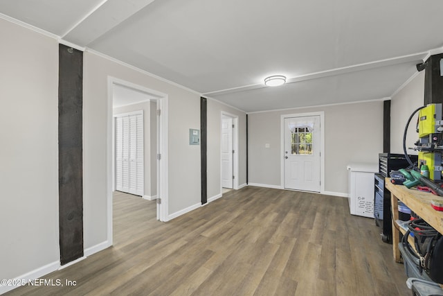 entryway featuring crown molding, baseboards, and wood finished floors