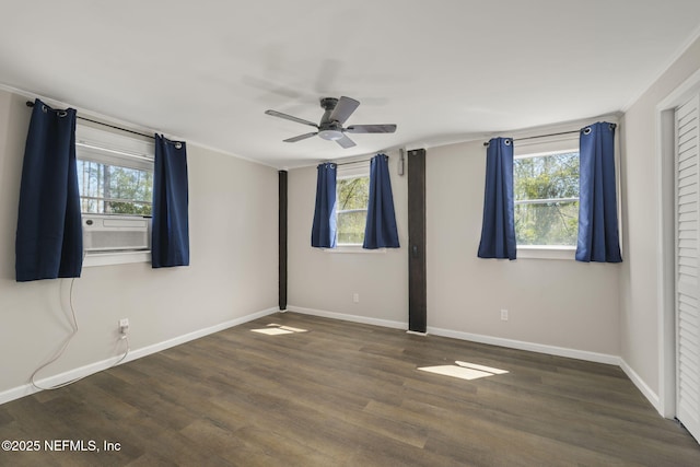 empty room featuring plenty of natural light, wood finished floors, and baseboards