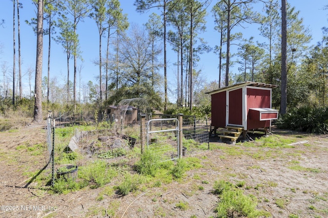 view of yard with an outbuilding, a storage unit, and fence