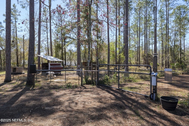 view of yard with an outdoor structure, a gate, and fence