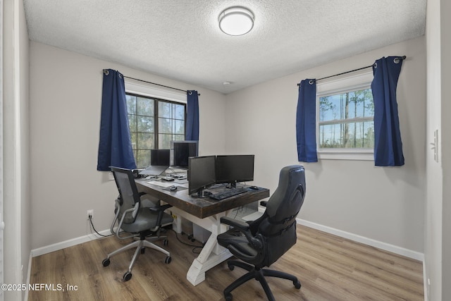 office space with baseboards, a healthy amount of sunlight, and wood finished floors