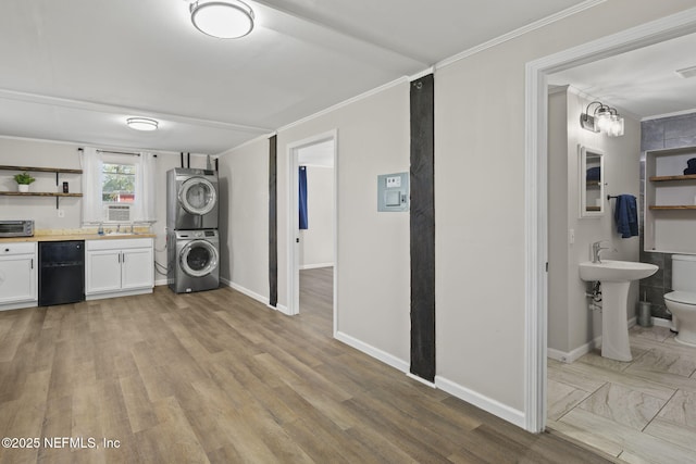 washroom with a sink, stacked washer / drying machine, laundry area, and crown molding