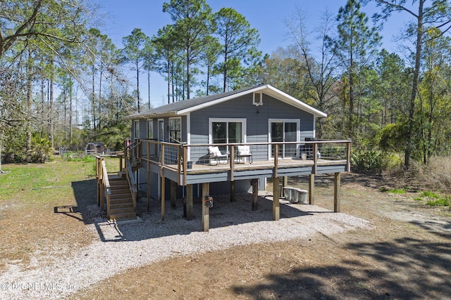 rear view of property featuring a wooden deck and stairs