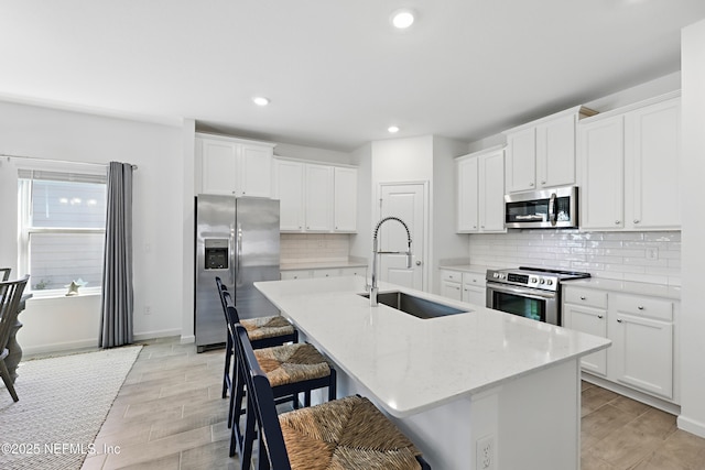 2965 Crossfield Dr, Green Cove Springs, FL 32043 - kitchen with tasteful backsplash, a sink, a kitchen bar, a center island with sink, and stainless steel appliances