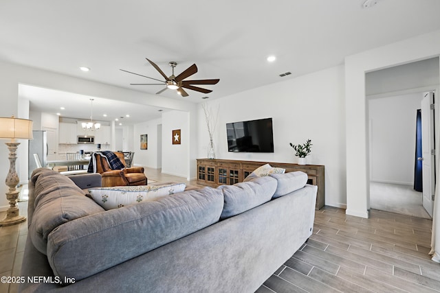 2965 Crossfield Dr, Green Cove Springs, FL 32043 - living room with visible vents, baseboards, recessed lighting, and ceiling fan with notable chandelier