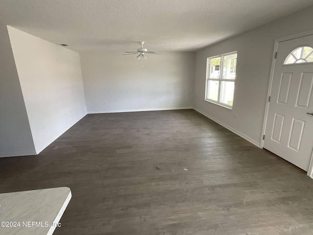 foyer featuring baseboards, dark wood-type flooring, ceiling fan, and a textured ceiling