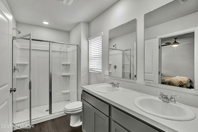 full bathroom featuring a shower stall, connected bathroom, wood finished floors, and a sink