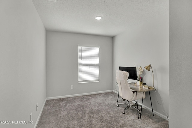 carpeted home office with a textured ceiling and baseboards