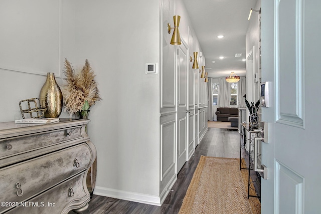 corridor featuring dark wood finished floors, recessed lighting, and baseboards