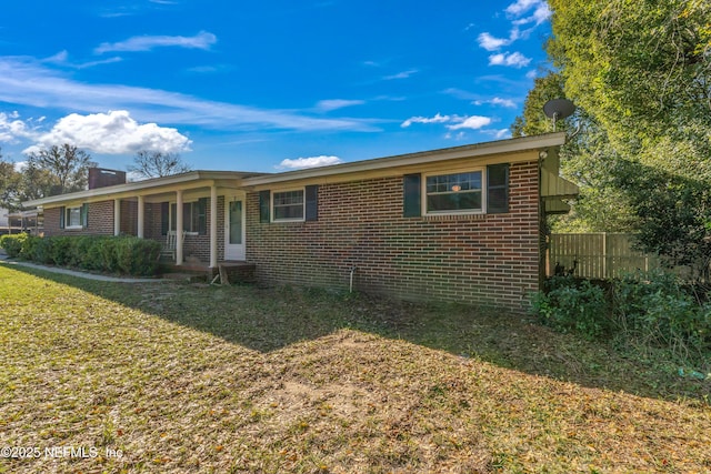 ranch-style house with a front lawn, a porch, fence, and brick siding