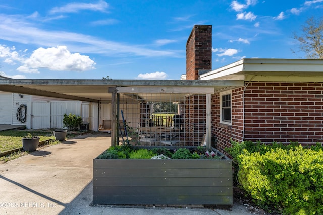 view of patio / terrace with concrete driveway and fence