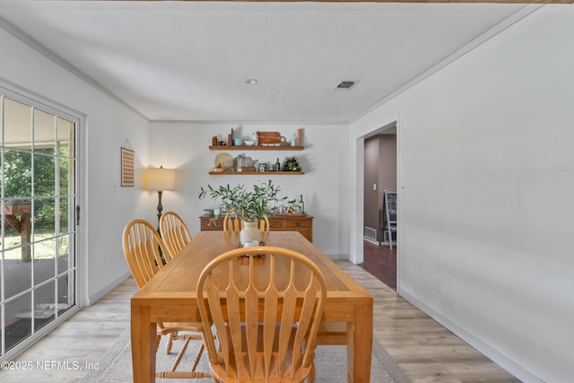 dining area featuring visible vents, baseboards, and light wood-style floors