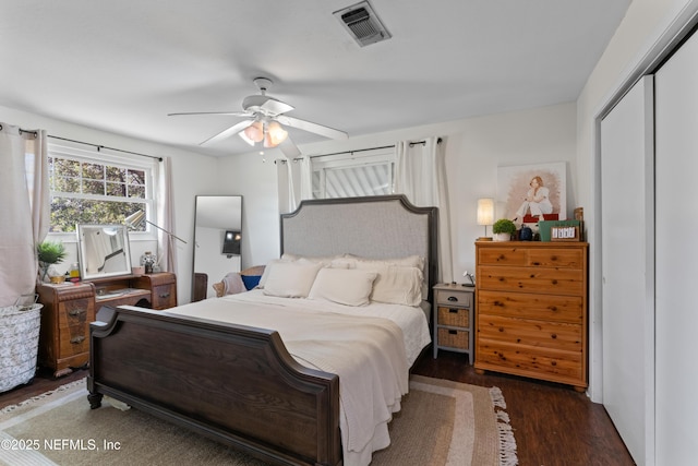 bedroom with a closet, visible vents, ceiling fan, and wood finished floors