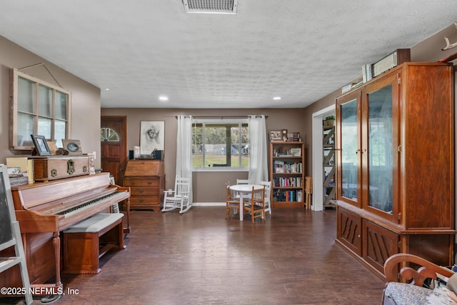 living area with recessed lighting, dark wood-style floors, visible vents, and a textured ceiling