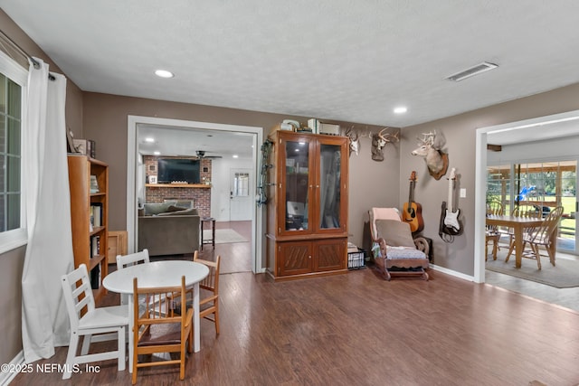 dining space with wood finished floors, visible vents, baseboards, a fireplace, and recessed lighting