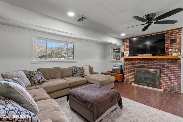 living area featuring visible vents, recessed lighting, a fireplace, wood finished floors, and a ceiling fan