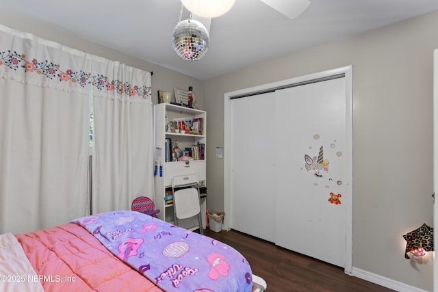 bedroom with a closet, baseboards, and wood finished floors