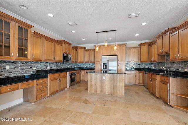 kitchen with brown cabinetry, visible vents, a kitchen island, a sink, and appliances with stainless steel finishes