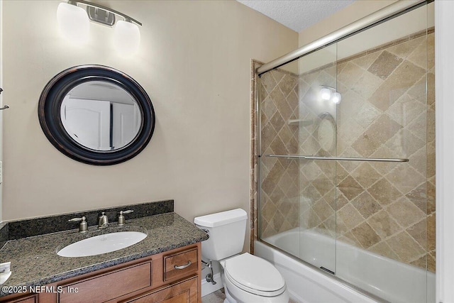 full bathroom featuring toilet, a textured ceiling, vanity, and shower / bath combination with glass door