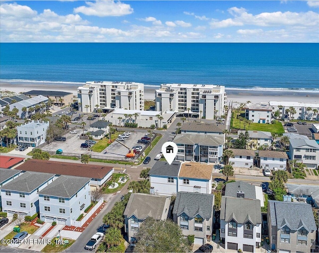 aerial view featuring a view of the beach, a water view, and a residential view