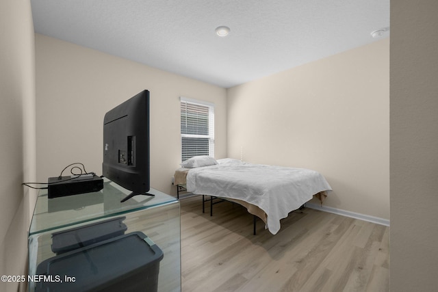 bedroom with baseboards and light wood finished floors