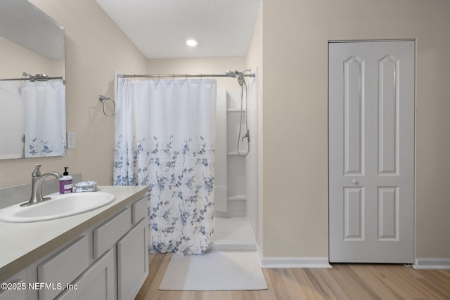 bathroom with vanity, a shower with curtain, wood finished floors, and baseboards