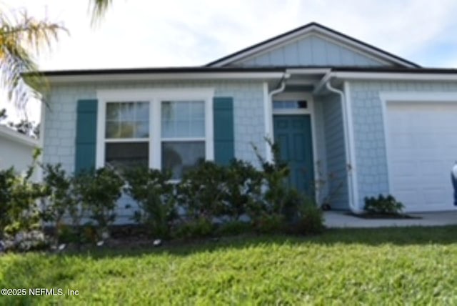 view of front of property with a front yard and a garage