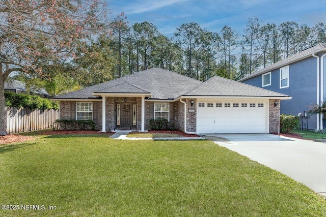 view of front of house with driveway, fence, roof with shingles, a front yard, and an attached garage