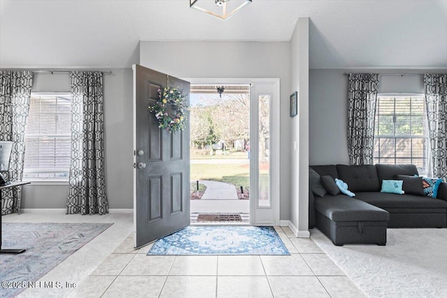 carpeted foyer entrance featuring tile patterned flooring and baseboards