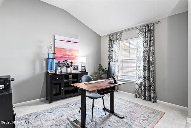 carpeted office featuring baseboards and vaulted ceiling