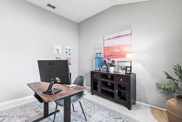 home office with visible vents, carpet flooring, baseboards, and vaulted ceiling