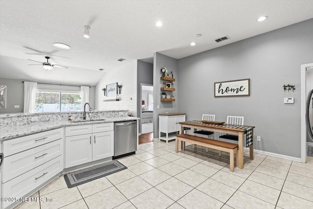 kitchen featuring ceiling fan, light tile patterned floors, stainless steel dishwasher, white cabinets, and a sink