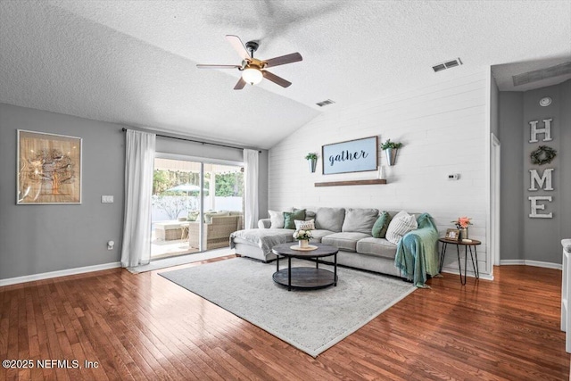 living area featuring hardwood / wood-style flooring, visible vents, and ceiling fan