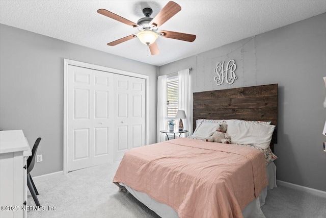 carpeted bedroom with a closet, a textured ceiling, and baseboards