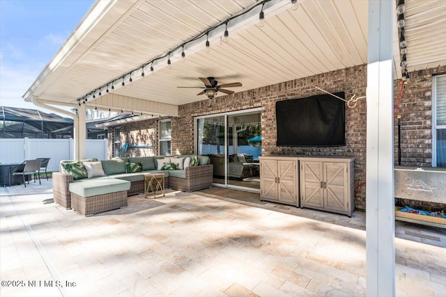 view of patio / terrace with an outdoor living space, ceiling fan, and fence