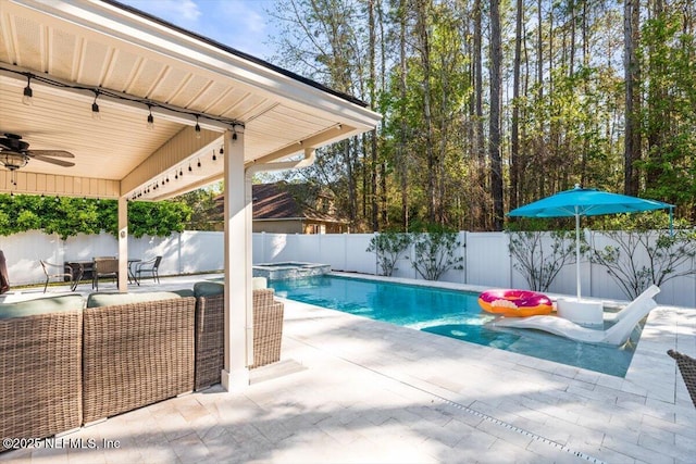 view of pool featuring a ceiling fan, a patio, a fenced backyard, and a pool with connected hot tub