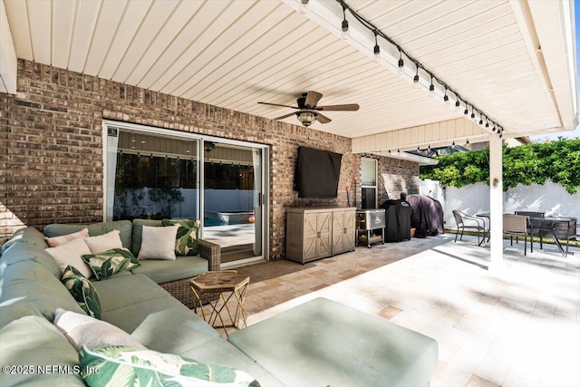 view of patio featuring an outdoor hangout area, outdoor dining space, a ceiling fan, and fence