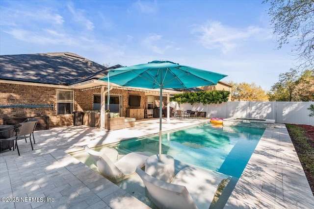 view of swimming pool with a fenced backyard, a pool with connected hot tub, and a patio