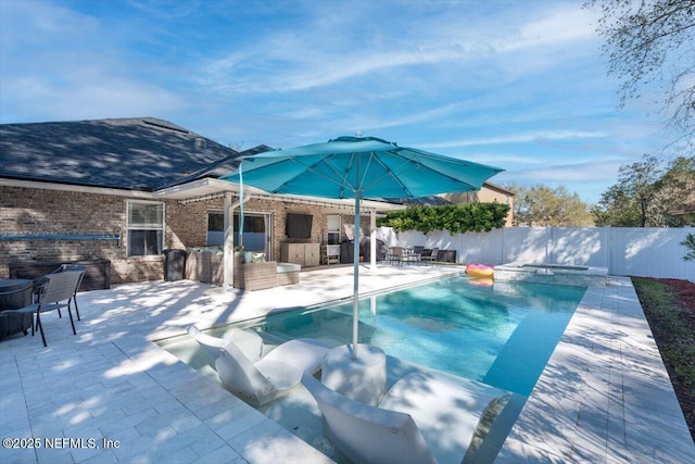 view of pool featuring a pool with connected hot tub, a patio area, and a fenced backyard