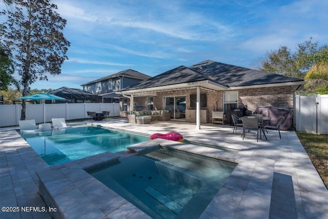 view of swimming pool with an outdoor living space, a pool with connected hot tub, a fenced backyard, and a patio area