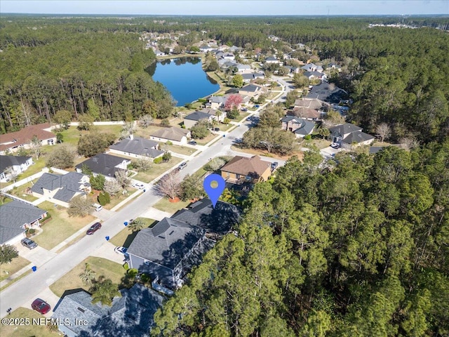 drone / aerial view with a forest view, a water view, and a residential view