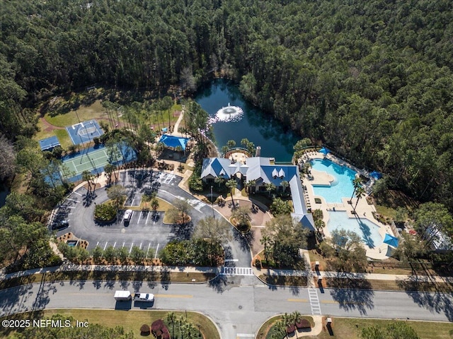 aerial view featuring a forest view and a water view