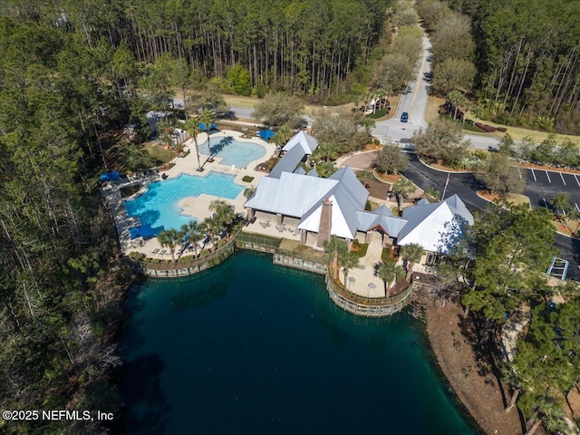 birds eye view of property featuring a forest view and a water view