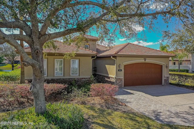 3808 Catania Pl, Jacksonville, FL 32224 - mediterranean / spanish-style home featuring a tile roof, stucco siding, a garage, stone siding, and driveway